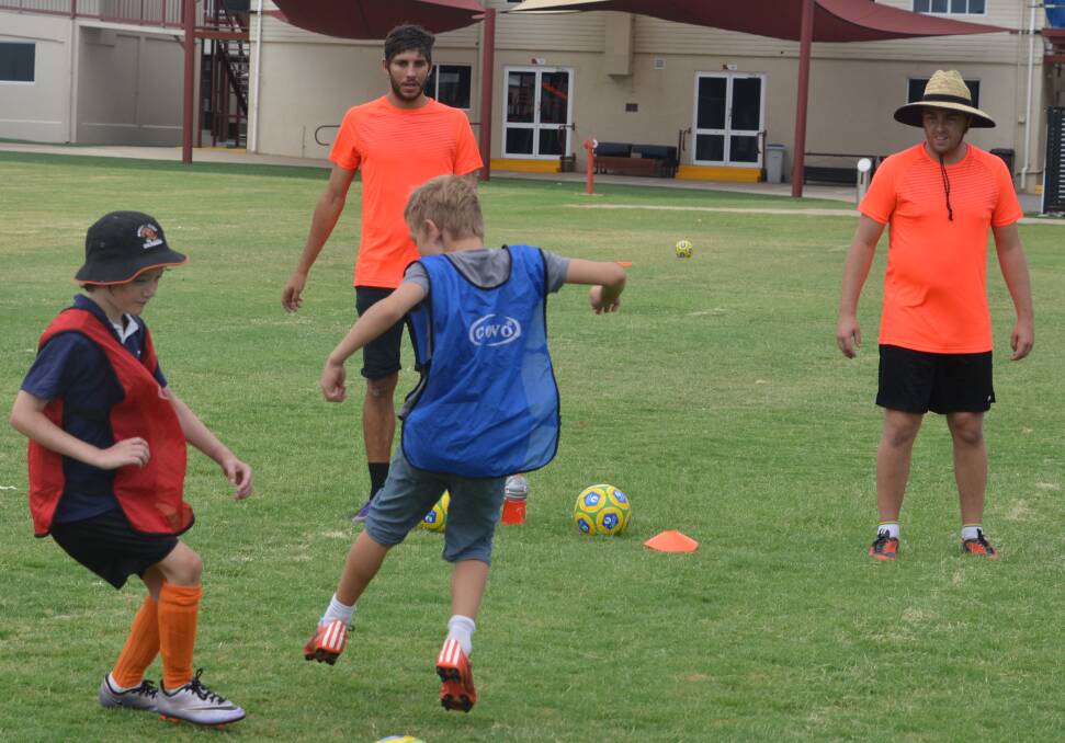 Dean Kelley (right) wants kids to learn the basics of soccer.