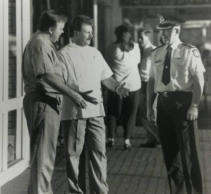 Police Beat state coordinator Snr Sgt Tony Schofield discusses a police beat in Mount Isa with Brett Muller of Menzies Amcal chemist and police superintendent Danny Black on July 25, 1995.