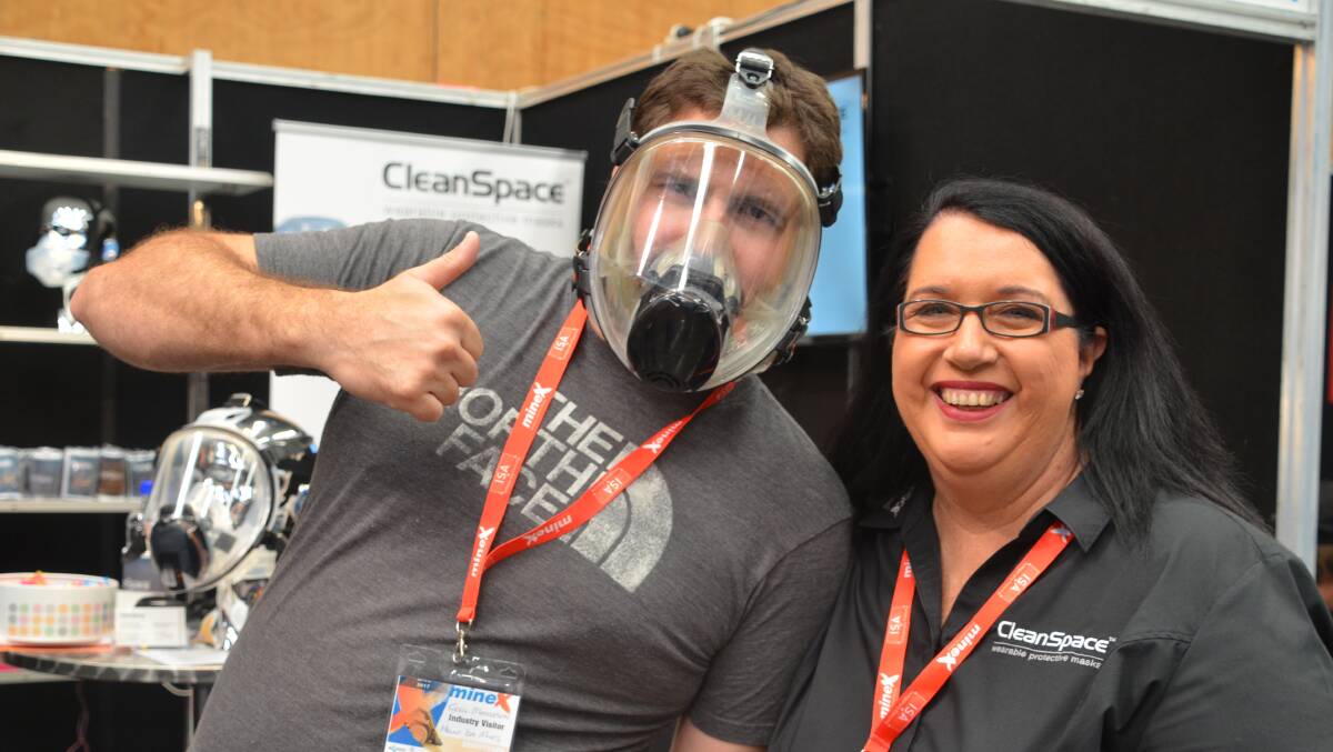 Tyrell Masterson of MIM tries out the CleanSpace respiratory protective mask at MineX with a representative of mask producer Pastec, Maria Fox.