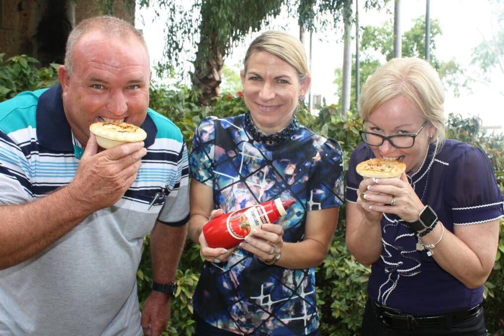 PIE TIME: Cr Paul Stretton and Cr Peta Macrae warm up for the pie eating competition, as Mayor Joyce McCulloch provides support with the sauce.
