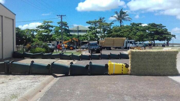 Wheelie bins and hay bales were used to help guide the croc back to water. (Supplied: Queensland Police Service)