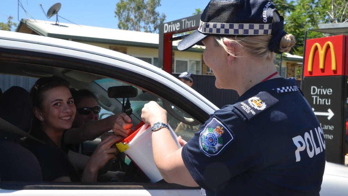 McSMILES: Sgt Renee Hanrahan collects funds for McHappy Day from Steph and Ash. Photo: Derek Barry