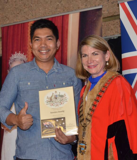 THUMBS UP: Christan Manuel gets his citizenship certificate from Mount Isa Mayor Joyce McCulloch. Photo: Derek Barry