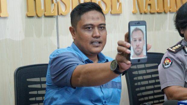 SUSPECT: The deputy director of narcotics for Bali police, Sudjarwoko, holds a photo of Joshua James Baker at a press conference. Photo: Amilia Rosa