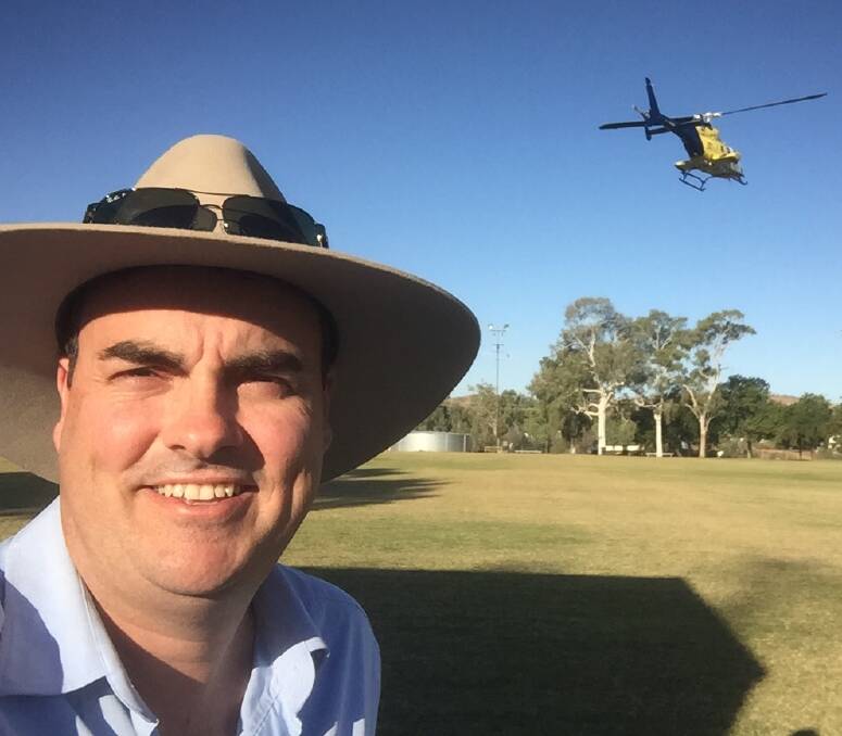 BIG CALL: Shadow Assistant Minister for North Queensland Jason Costigan takes a selfie as a Lifeflight rescue chopper takes off behind at Kruttschnitt Oval. Photo: supplied