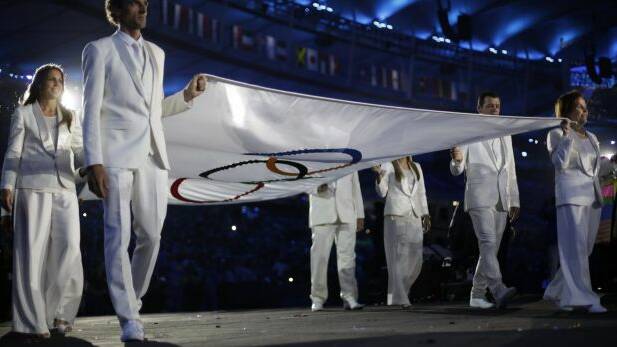 The Olympic flag is carried by Brazilian legends in the opening ceremony. (Photo: AP).
