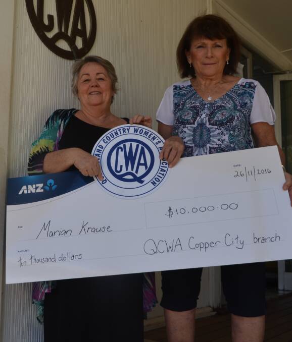 BIG WIN: Mount Isa QCWA branch president Judy Martyr (left) presents Marian Krause win her cheque for $10,000. Photo: Derek Barry