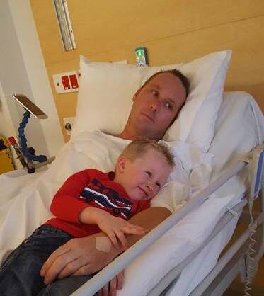 FAMILY: Zayb Jobson cuddles up to his father in hospital as the footballer continues his recovery.
