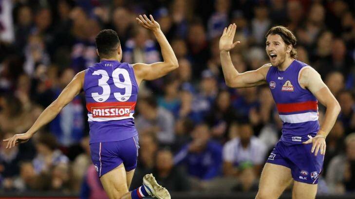 Undaunted: Jason Johannisen celebrates a goal with Marcus Bontempelli, who had a great game despite physical attention from the Kangaroos. Photo: AFL Media/Getty Images
