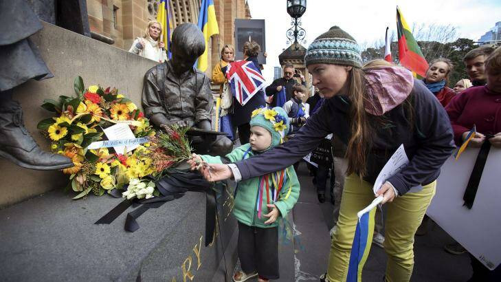 Ukrainian Community placing a reef of flowers and black ribbons at the Mary MacKillop Memorial, St Mary Cathedral in Sydney In memory of the passengers and crew that died on the Malaysian MH17 flight Photo: Fiona Morris