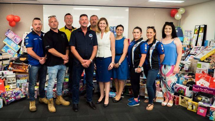 Child Safety Minister Shannon Fentiman, middle, and Melissa Delaware, fourth from right, with the 2300 presents donated to the Kids in Care appeal. Photo: Supplied