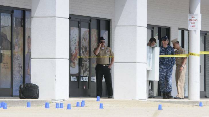 Reserve Recruitment personnel stand outside a Navy recruiting building as the area is cordoned off with blue shell casing markers. Photo: Tim Barber