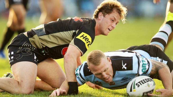Matt Moylan of the Panthers loses the ball after a heavy hit by by Luke Lewis of the Sharks. Photo: Matt King