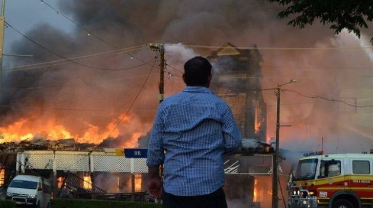 An onlooker watches on as the Royal Hotel, Roma burns. Photo: APN