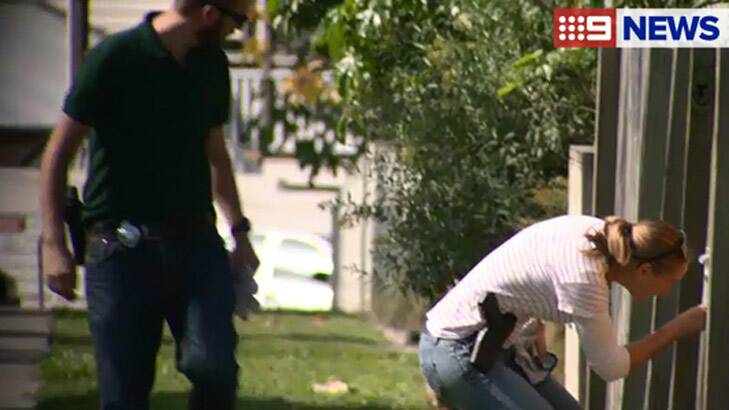 Police search properties on Key Street, Morningside, for clues to Peter Milos's death. Photo: Nine News