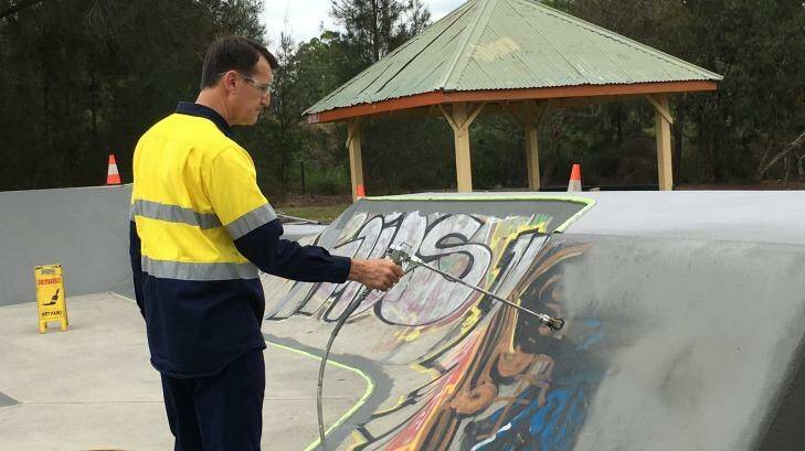 Lord Mayor Graham Quirk paints over graffiti at the council's Stafford Heights skate park. Photo: Cameron Atfield