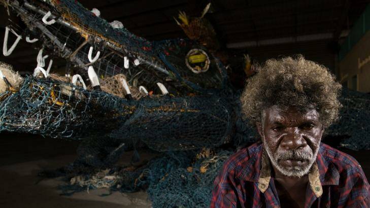 Eric Norman with the almost eight-metre ghost net sculpture of a crocodile he created with other Pormpuraaw artists for the Cairns Indigenous Art Fair. Photo: Janie Barrett