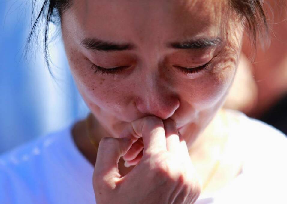 A family member of a passenger onboard the MH370 cries at a temple in Beijing in September, 2014.  Photo: KIM KYUNG-HOON / Reuters