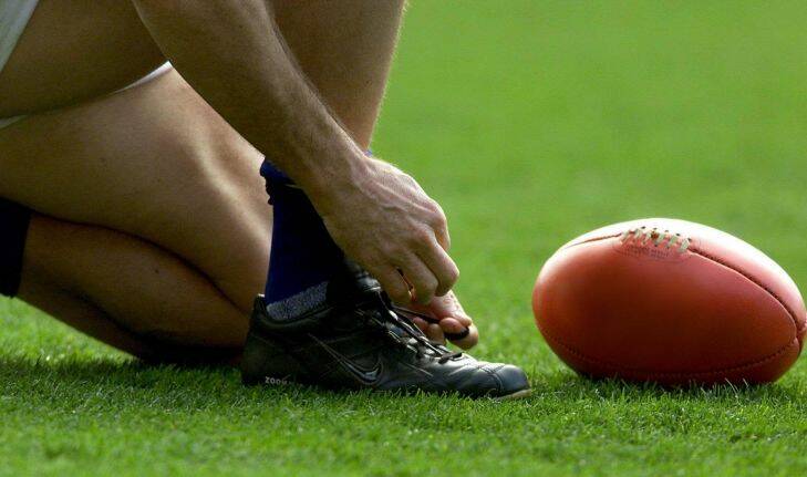 scz0200908.006.007.picture Sebastian Costanzo.The Age.Sport.
File pic 'Tying the bootlaces"
2002 AFL (Australian Football League) - Round 1:  Qualifying Finals - Melbourne versus Kangaroos - MCG Ground.
- generic AFL football

foot , ball , sherrin
