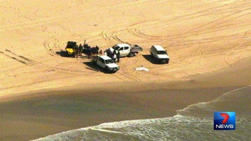 Police at the scene where a man's body washed up on South Stradbroke Island. Photo: Channel Seven/Twitter