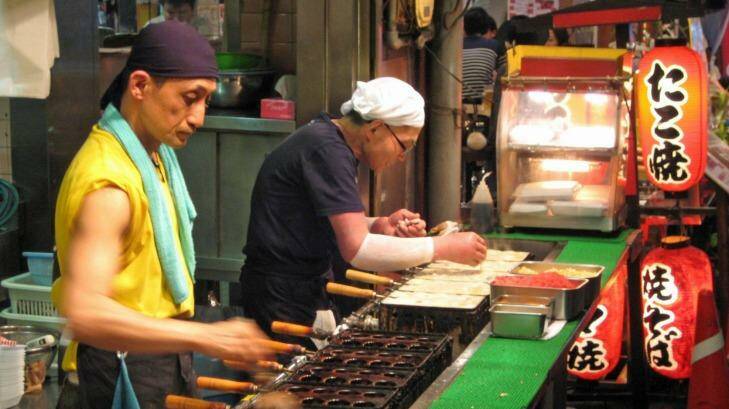 Osaka street vendors preparing fried octopus balls (takoyaki). Photo: Osaka Tourism