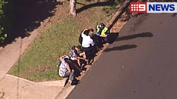 People are comforted outside a Inala home where fire claimed the life of a 61-year-old woman. Photo: Channel 9