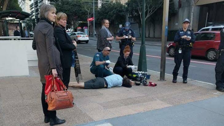 Paramedics treat Mark English, allegedly coward punched on Ann Street in the Brisbane CBD. Photo: Jorge Branco