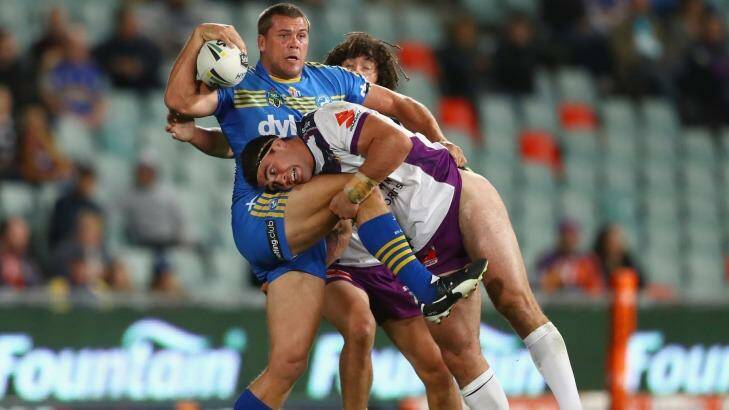 Danny Wicks of the Eels is tackled by Dale Finucane of the Storm.