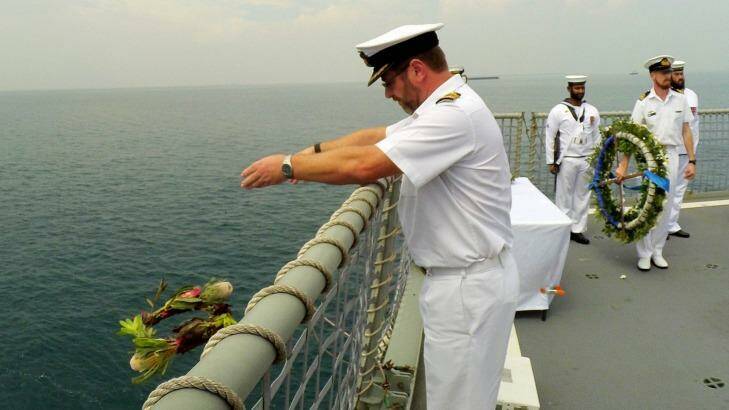 Ivan Ingham, captain of the present-day HMAS Perth, casts a wreath into the waters of the Sunda Strait to remember those who died while fighting the Imperial Japanese Navy on the first HMAS Perth in World War II. Photo: Jefri Tarigan