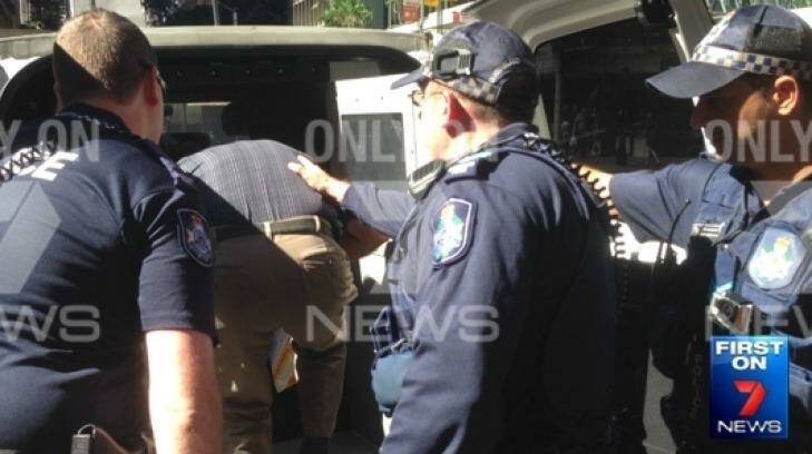 Police detain a man after over a flag burning. Photo: Seven News