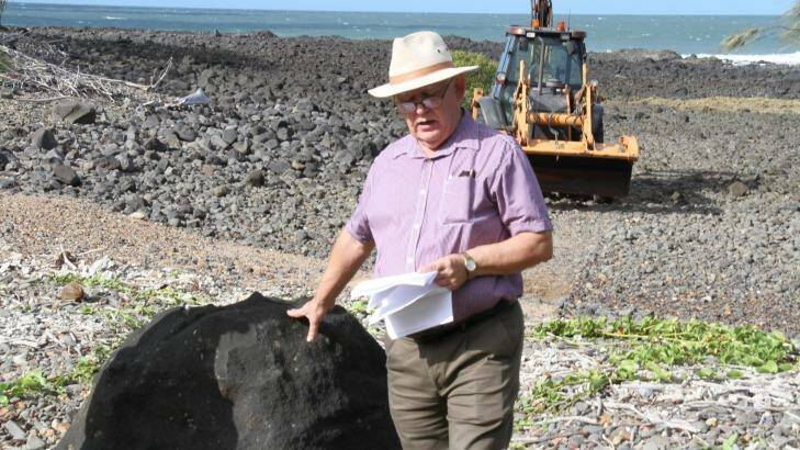 Kevin Lindeberg with the basalt boulder on Mon Repos Beach. Photo: Supplied Photo: Supplied