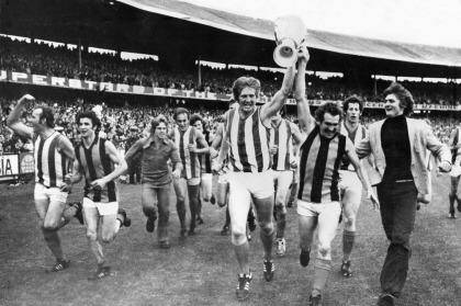 North Melbourne run around the oval with the premiership cup after the 1975 grand final. Photo: File