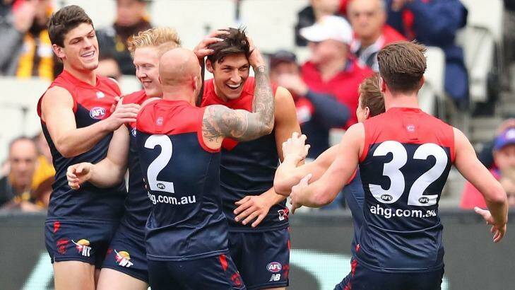 The Demons get around first-gamer Sam Weideman after he kicked a goal with his first kick in the AFL. Photo: Scott Barbour