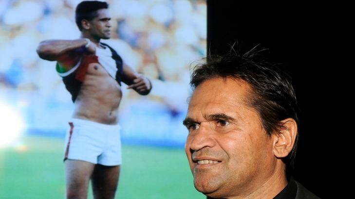 Nicky Winmar in 2013, next to the famous picture of him taken in 1993. Photo: Sebastian Costanzo