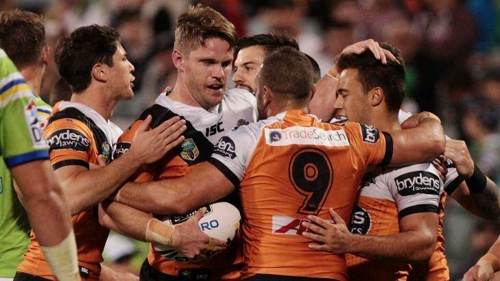 Rare bright spot: Chris Lawrence is congratulated by Tigers teammates after scoring a try during the match against Canberra. Photo: Stefan Postles