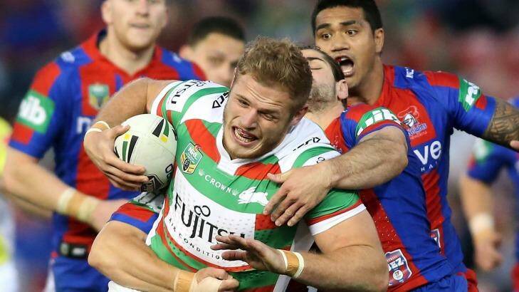 Tom Burgess of the Rabbitohs is tackled by the Knights defence. Photo: Tony Feder