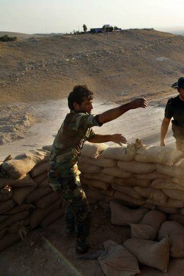 Vantage point: Peshmerga fighters pile up sandbags to make a gun placement on the road to Makhmur. Photo: Ahmed Jadallah