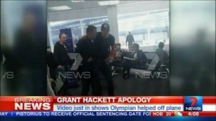 Grant Hackett is helped by a fellow passenger after the flight from Adelaide to Melbourne. Photo: Channel Seven