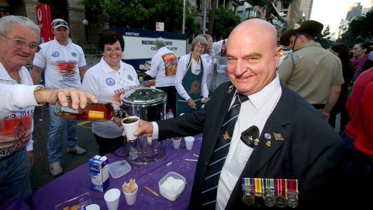 Darby Ashton, who served in Vietnam in 1965-1967, gets his coffee topped with rum by Lions volunteers Ross and Kim Forrest after more than 40,000 people gathered at the Shrine of Remembrance for the Brisbane Anzac Day dawn service. Photo: Michelle Smith