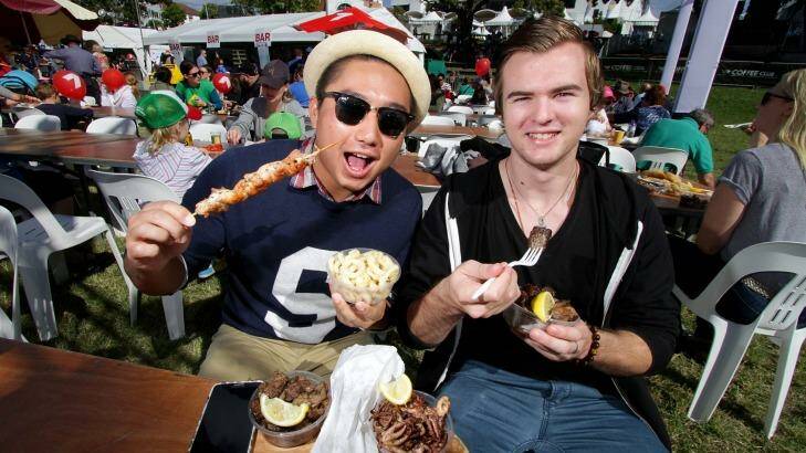 Michael Huynh and Luke Spiteri enjoy the food at the 2015 Paniyiri Festival at Musgrave Park. Photo: Michelle Smith