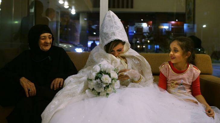 Rasha Kareem (centre) with her new mother-in-law and her niece at the Baghdad Hotel in the city's Saadoun district. There were 22 weddings at the hotel on Thursday night. Photo: Kate Geraghty