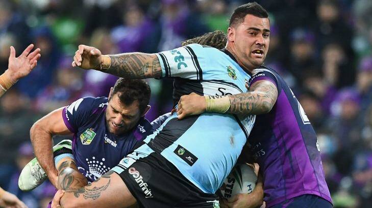 Hard to bring down: Cameron Smith hangs onto Andrew Fifita. Photo: Quinn Rooney