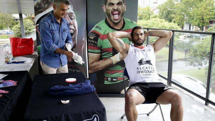 This won't hurt a bit: A Colgate official helps Greg Inglis with his mouthguard fitting at Redfern Oval on Friday.  Photo: Edwina Pickles