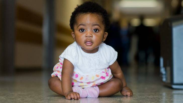 Angela Merkel Ade, 6 months, sits in a corridor in the Oststadtkrankenhaus refugee accommodation in Hanover, Germany. Her mother Ophelya Ade, 26, named her after the German chancellor.  Photo: Julian Stratenschulte