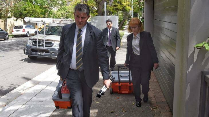 Raid: Detectives leave the office of NRL player agent Wayne Beavis.  Photo: Nick Moir