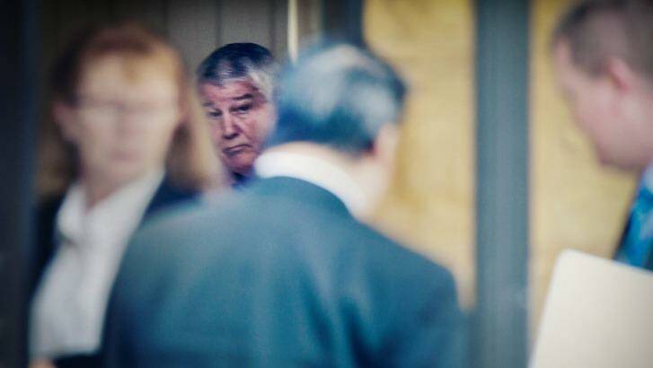 Targeted: Wayne Beavis inside his house as it is raided by the NSW fraud squad. Photo: Nick Moir