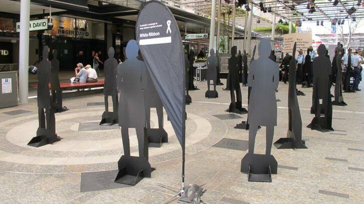 Silhouettes stand in the Queen Street Mall for White Ribbon Day. Photo: Claudia Jambor