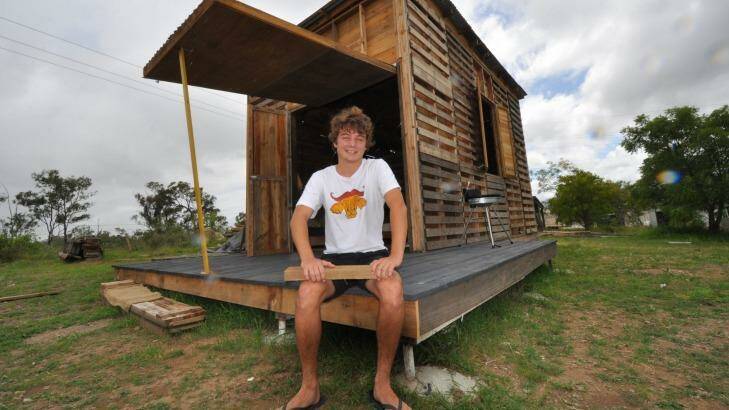 Angus Hughes with the prototype pallet house he built outside Rockhampton over five months. Photo: Supplied