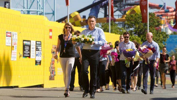 Dreamworld chief executive Craig Davidson and his employees leave flowers at the site on Wednesday. Photo: Glenn Hunt