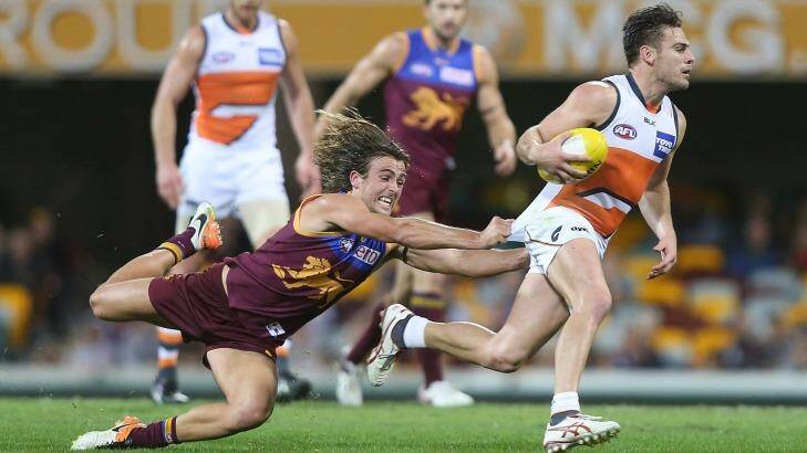 Sums it all up: Giant Stephen Conigliois is just beyond the reach of Brisbane's Rhys Mathieson on Sunday night at the Gabba. Photo: Chris Hyde